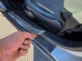 a person holding a piece of luggage in the trunk of a car