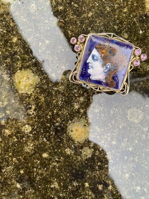 un gros plan sur le portrait d'une femme représenté sur une broche de forme carrée