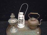 a metal tray with a tea kettle and a lantern on it