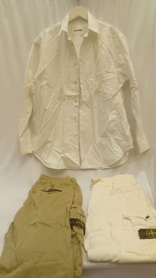 une chemise blanche, un pantalon et une chemise blanche posés sur une table