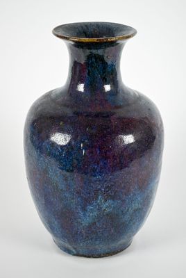 a blue vase that is sitting on a white surface