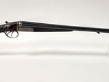 un vieux fusil au canon en bois, posé sur un socle transparent