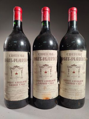 trois bouteilles de vin rouge posées côte à côte sur une table