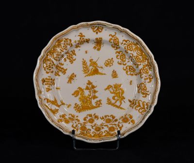 assiette jaune et blanche ornée d'un motif représentant un dragon