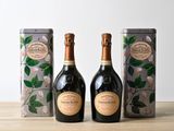 deux bouteilles de champagne posées l'une à côté de l'autre sur une table