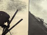 two posters on the wall of a building with skis on them