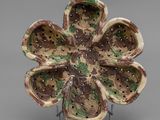 a ceramic flower that is sitting on top of a stand