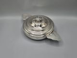 a silver plated teapot with a lid on a white surface