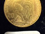 l'image d'une pièce d'or posée sur une surface noire, accompagnée d'une étiquette blanche