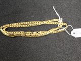 a close up of a gold chain with a tag on it