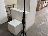 un appareil photo posé sur un trépied à côté d'une pile de cartons