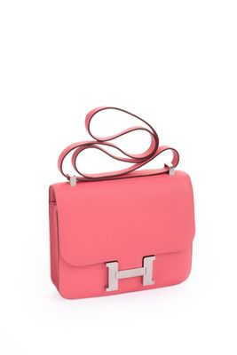 a small pink bag with a metal handle on a white background