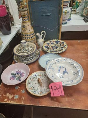 de nombreuses assiettes et vases posés sur une table dans une pièce