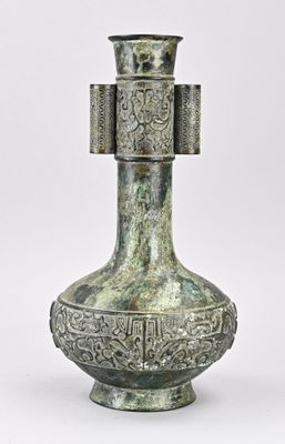 un vase en argent surmonté d'une croix