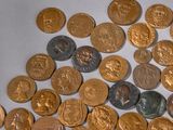 a pile of gold and silver coins on a white surface