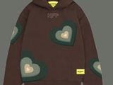 a brown hoodie with hearts on it and a yellow tag on the chest