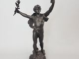 une statue représentant un homme tenant une couronne et un oiseau