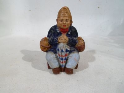 une figurine représentant un homme assis par terre