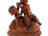 une statue représentant un garçon et une fille assis sur un rocher