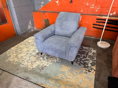 une chaise bleue posée sur un tapis dans une pièce