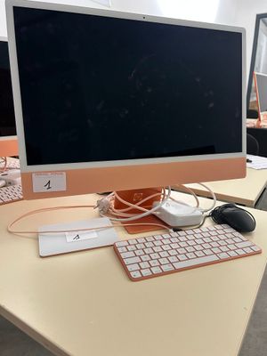 a computer monitor sitting on a desk with a keyboard and mouse