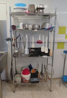 une étagère en métal sur laquelle sont posés des casseroles et des poêles