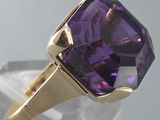 a close up of a ring with a purple stone in it