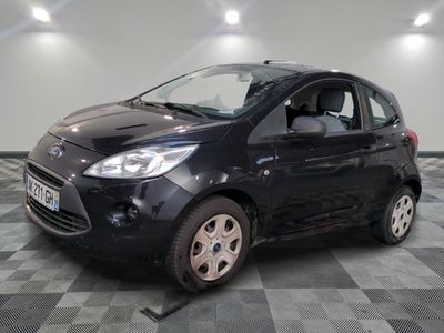 la photo d'une petite voiture noire garée sur un sol en damier