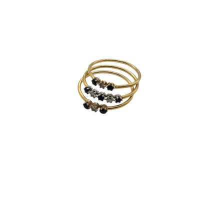 a close up of a gold ring with black stones on it