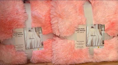 several pink and white fluffy pillows on display in a store