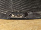 a close up of a black speaker on a wooden table