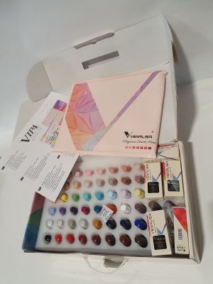 une boîte d'aquarelles posée sur une table blanche