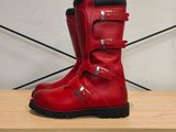 quelqu'un porte une paire de bottes rouges ornées de boucles