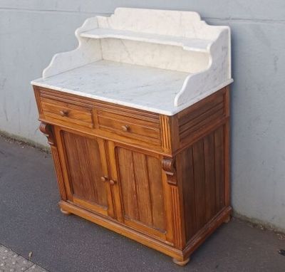 a wooden cabinet with a marble top on a sidewalk
