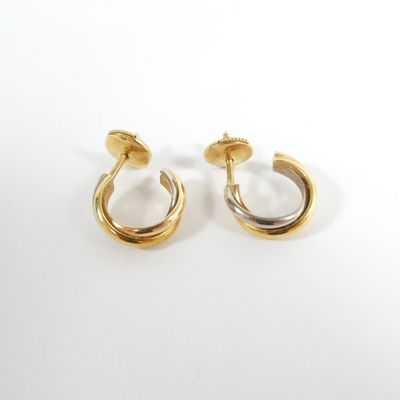 a pair of gold and silver hoop earrings on a white background