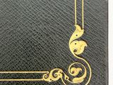 an old black book with a gold design on the cover