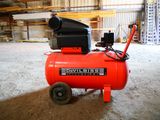 a red air compressor sitting in the middle of a room