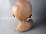 a clay sculpture of a woman ' s head on a table