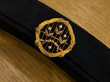 a black tie with a gold and red brooch on it