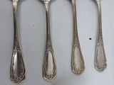 six spoons and a spoon rest on a white surface