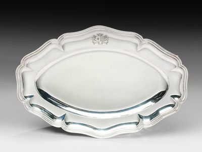 une assiette en argent ornée d'un motif floral sur le bord