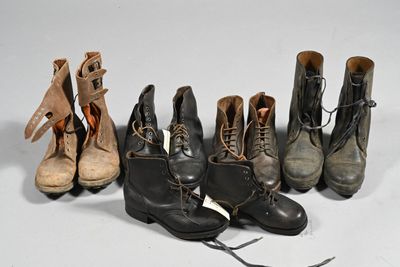 Plusieurs paires de bottes sont alignées sur une surface blanche