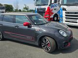 une petite voiture garée sur un parking à côté d'un semi-remorque