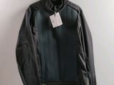 black leather jacket hanging on a hanger with a tag on it
