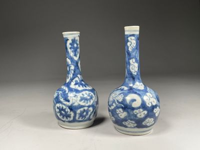 pair of blue and white vases on a table with a gray background