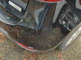 the rear end of a red car with a denting bumper