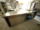 un grand îlot de cuisine en inox au milieu de la cuisine