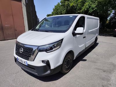 la camionnette blanche est garée sur le parking à côté d'un bâtiment
