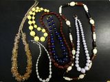 plusieurs colliers de différentes couleurs et tailles posés sur un fond noir