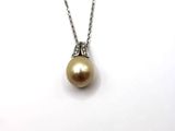 a close up of a necklace with a pearl on a chain